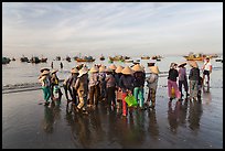 Women gather on beach to collect freshly caught fish. Mui Ne, Vietnam (color)