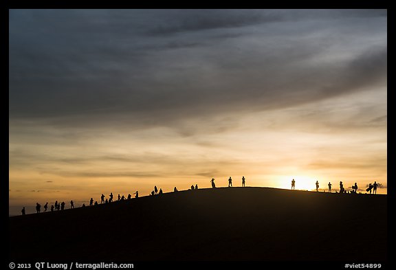 Tourists watching sunset from dune. Mui Ne, Vietnam