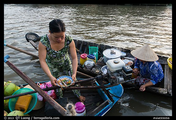 Woman gets bowl of noodles from floating market. Can Tho, Vietnam (color)