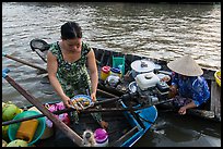 Woman gets bowl of noodles from floating market. Can Tho, Vietnam ( color)