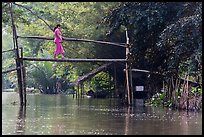 Woman crossing monkey bridge. Can Tho, Vietnam (color)