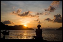 Sitting woman in silhouette and sunrise, Con Son. Con Dao Islands, Vietnam ( color)