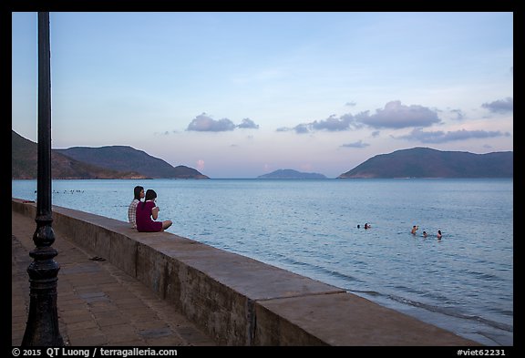 Young women sitting on seawall, evening, Con Son. Con Dao Islands, Vietnam (color)