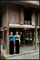 Two thai women standing in front of their stilt house, Ban Lac village. Northwest Vietnam (color)