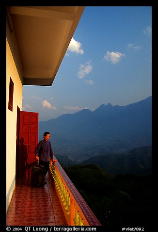 Traveler on a hotel balcony, looking at the Hoang Lien Mountains. Sapa, Vietnam
