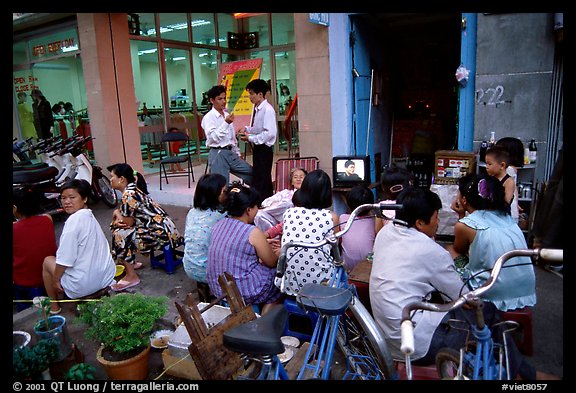 Watching TV on the street with the neighboors. Ho Chi Minh City, Vietnam (color)