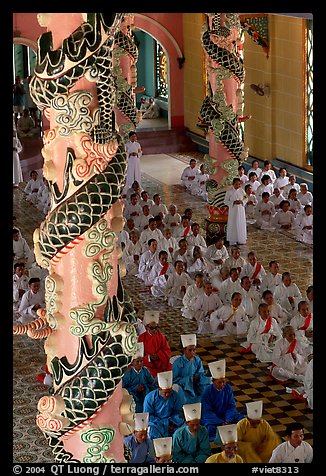 Priests and ornate columns inside the Great Caodai Temple. Tay Ninh, Vietnam