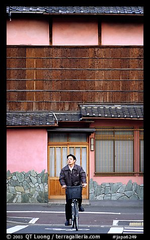 Bicyclist in front of a traditional style house. Kyoto, Japan