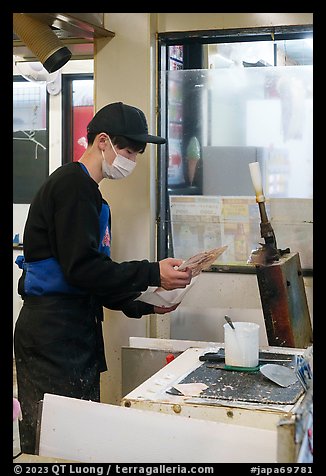 Man preparing tako senbei octopus cracker. Enoshima Island, Japan (color)