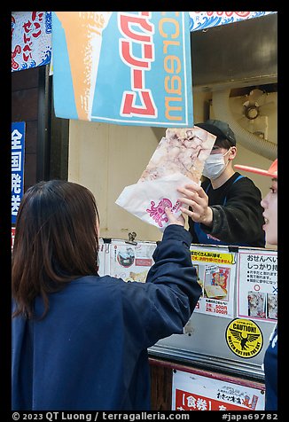 Customer receiving tako senbei octopus cracker. Enoshima Island, Japan (color)