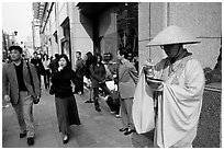 Buddhist monk seeking alms in front of a Ginza department store. Tokyo, Japan (black and white)