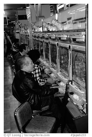 Playing a gambling maching. Tokyo, Japan (black and white)