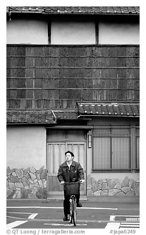 Bicyclist in front of a traditional style house. Kyoto, Japan
