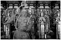 Some of the 1001 statues of the thousand-armed Kannon (buddhist goddess of mercy), Sanjusangen-do Temple. Kyoto, Japan (black and white)