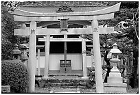 Tori gate at the entrance of a shrine inner grounds. The act of passing through purifies the soul.. Kyoto, Japan (black and white)