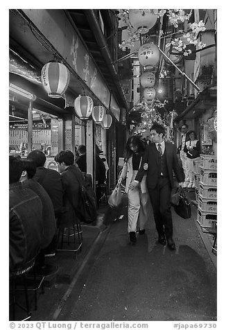 Couple walking in Omoide Yokocho, Shinjuku. Tokyo, Japan (black and white)