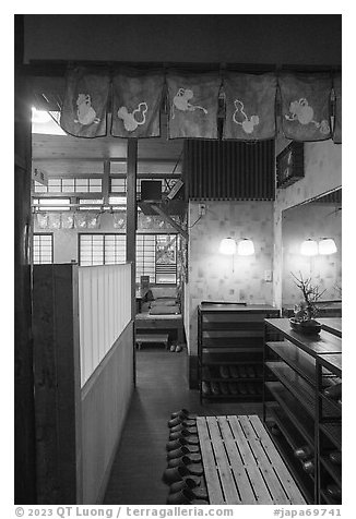 Restaurant entrance with slippers and shoe racks, Fujisawa. Japan (black and white)