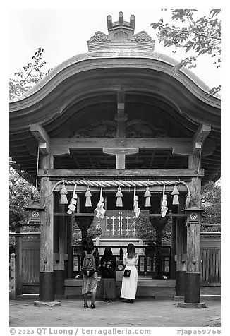 Women worshiping at Okutsumiya, the original shrine of the island. Enoshima Island, Japan (black and white)