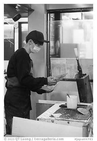 Man preparing tako senbei octopus cracker. Enoshima Island, Japan (black and white)