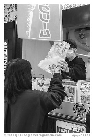 Customer receiving tako senbei octopus cracker. Enoshima Island, Japan