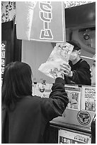 Customer receiving tako senbei octopus cracker. Enoshima Island, Japan ( black and white)