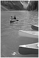 Colorful canoes and conoeists on Moraine Lake. Banff National Park, Canadian Rockies, Alberta, Canada ( black and white)