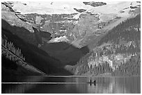 Rowers on Lake Louise, below Victoria Glacier, early morning. Banff National Park, Canadian Rockies, Alberta, Canada (black and white)