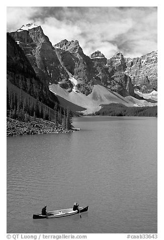 Canoeists below  Wenkchemna Peaks, Moraine Lake, mid-morning. Banff National Park, Canadian Rockies, Alberta, Canada (black and white)