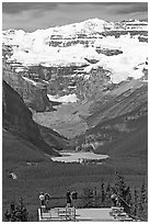Tourists at observation platform, looking at  Lake Louise and  Victoria Peak. Banff National Park, Canadian Rockies, Alberta, Canada ( black and white)