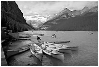 Red canoes at boat dock, Lake Louise, morning. Banff National Park, Canadian Rockies, Alberta, Canada (black and white)