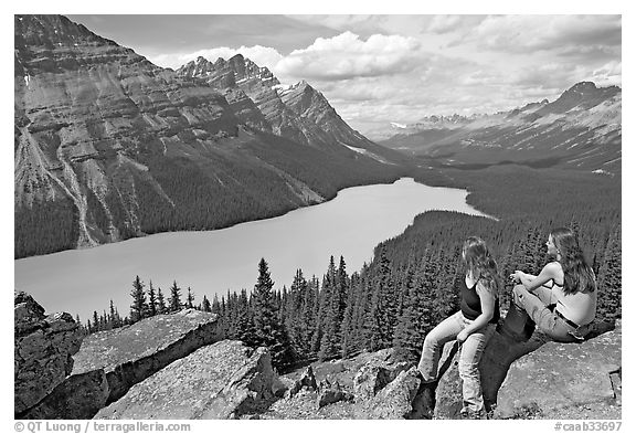 Tourists sitting on a rook overlooking Peyto Lake. Banff National Park, Canadian Rockies, Alberta, Canada (black and white)