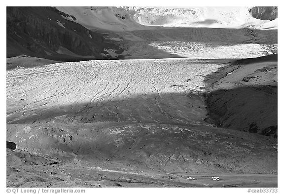 Base of Athabasca Glacier with cars parked on lot. Jasper National Park, Canadian Rockies, Alberta, Canada