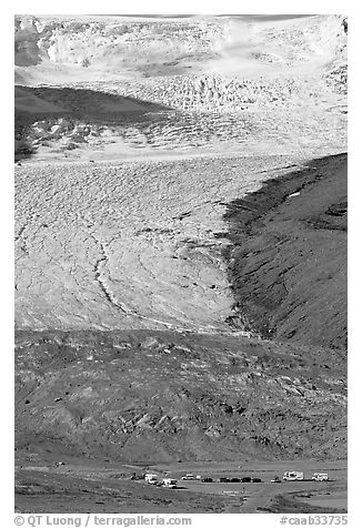 Parking lot dwarfed by Athabasca Glacier. Jasper National Park, Canadian Rockies, Alberta, Canada (black and white)