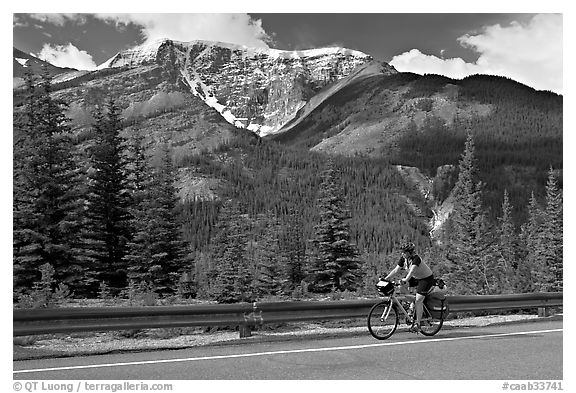 Woman cycling the Icefields Parkway. Jasper National Park, Canadian Rockies, Alberta, Canada (black and white)