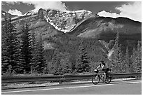 Woman cycling the Icefields Parkway. Jasper National Park, Canadian Rockies, Alberta, Canada (black and white)