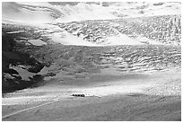 Distant view of snowcoaches parked at the base of the lower icefall on the Athabasca Glacier. Jasper National Park, Canadian Rockies, Alberta, Canada ( black and white)