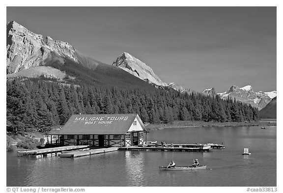 Boat house and canoe beneath Leh and Samson Peaks,  Maligne Lake. Jasper National Park, Canadian Rockies, Alberta, Canada (black and white)