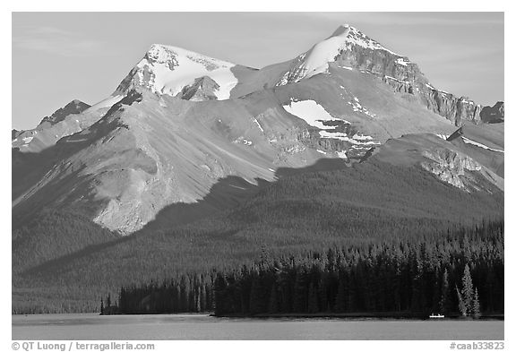 Canoe dwarfed by the Mt Charlton and Mt Unwin surrounding Maligne Lake. Jasper National Park, Canadian Rockies, Alberta, Canada