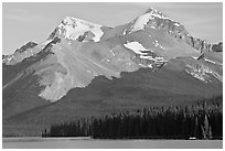 Canoe dwarfed by the Mt Charlton and Mt Unwin surrounding Maligne Lake. Jasper National Park, Canadian Rockies, Alberta, Canada ( black and white)