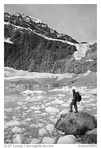 Hiker with backpack looking at iceberg-filed lake, glaciers, and mountain, Mt Edith Cavell. Jasper National Park, Canadian Rockies, Alberta, Canada (black and white)
