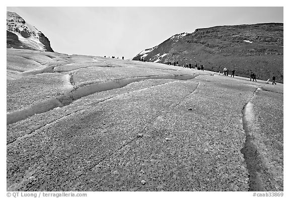 Crevasses on Athabasca Glacier with a line of tourists in the background. Jasper National Park, Canadian Rockies, Alberta, Canada