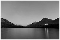 Waterton lake by night with stars in the sky in lights of Price of Wales Hotel. Waterton Lakes National Park, Alberta, Canada (black and white)