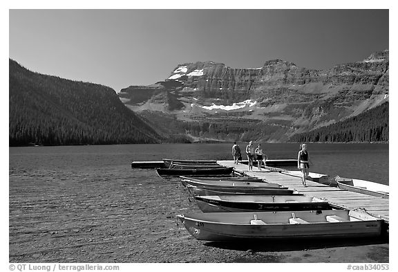 Dock and small boats, with tourists walking down, Cameron Lake. Waterton Lakes National Park, Alberta, Canada (black and white)