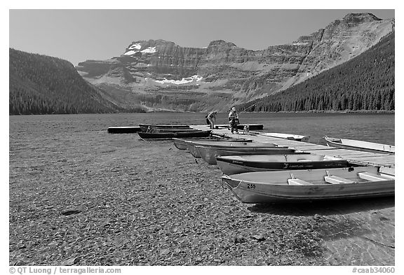 Fishermen walking on dock after unloading a canoe, Cameron Lake. Waterton Lakes National Park, Alberta, Canada (black and white)