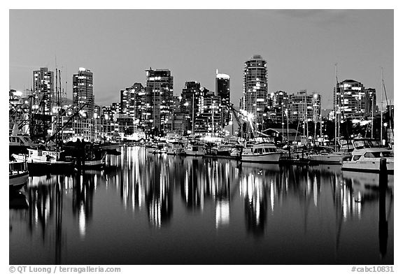 Fishing boats and skyline light reflected at night. Vancouver, British Columbia, Canada