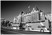 Red double-decker tour busses in front of Empress hotel. Victoria, British Columbia, Canada (black and white)