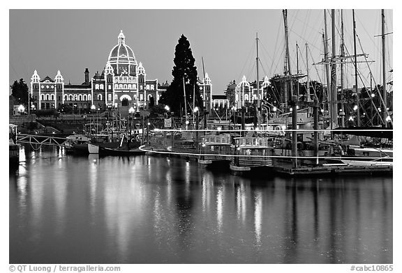 Boats in inner harbor with a trail of lights and parliament building lights. Victoria, British Columbia, Canada (black and white)