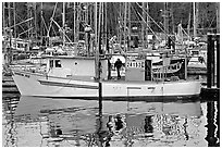 Fishing boat and reflections in harbor, Uclulet. Vancouver Island, British Columbia, Canada (black and white)