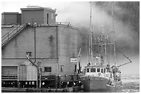 Commercial fishing boat next to a fishery, Tofino. Vancouver Island, British Columbia, Canada (black and white)