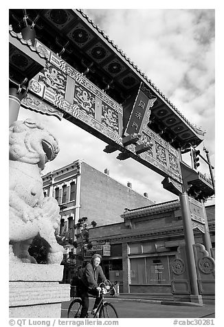 Bicyclist passing Gate of Harmonious Interest. Victoria, British Columbia, Canada (black and white)